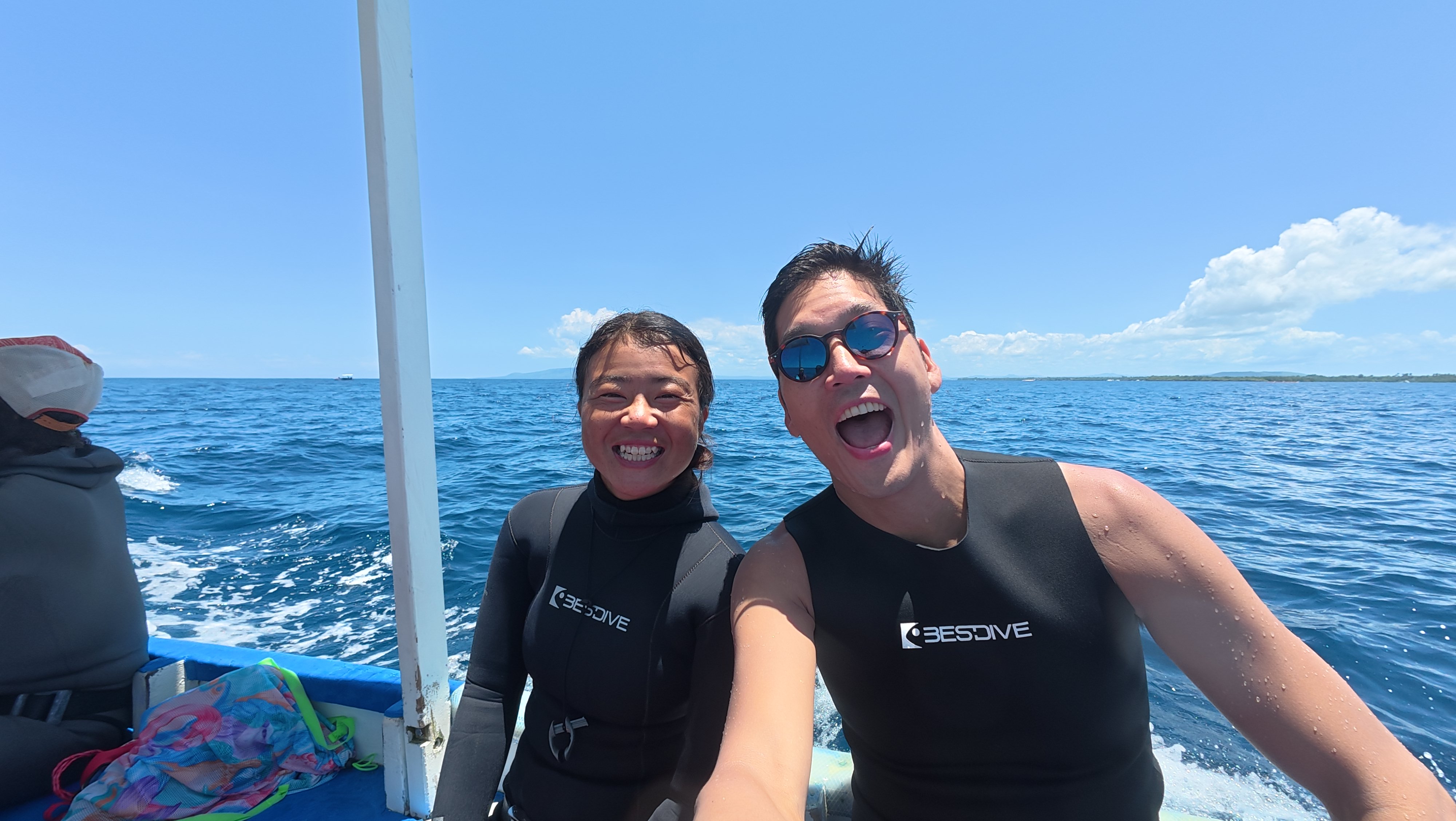 Two freedivers smiling on a boat after a dive
