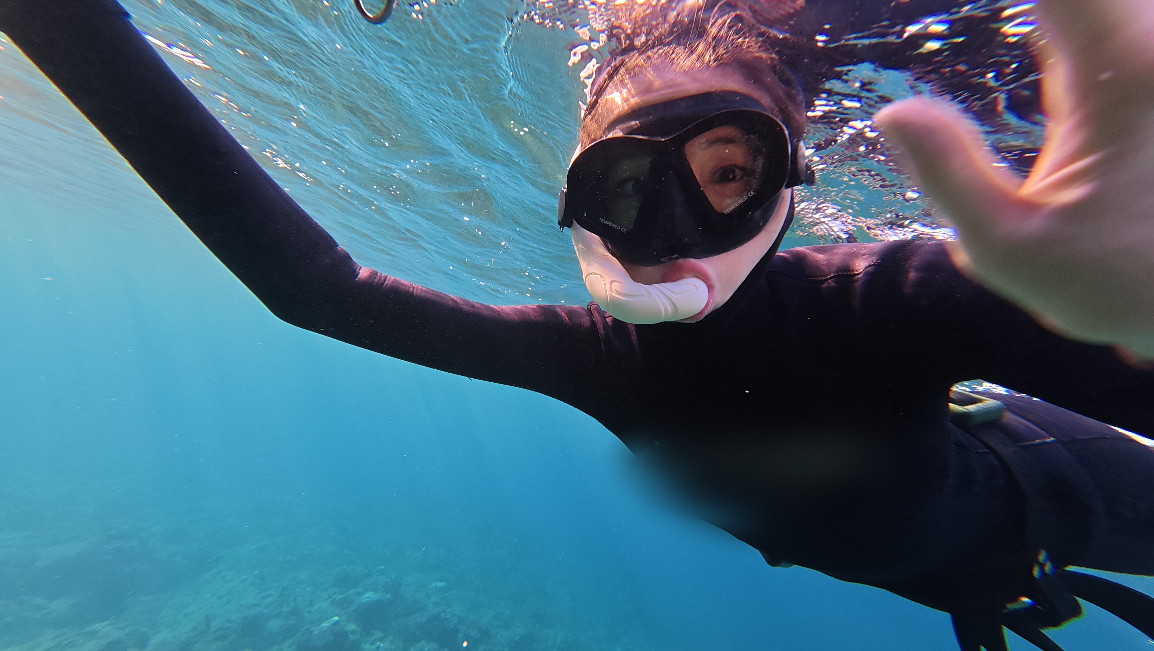 Freediver smiling underwater near the surface